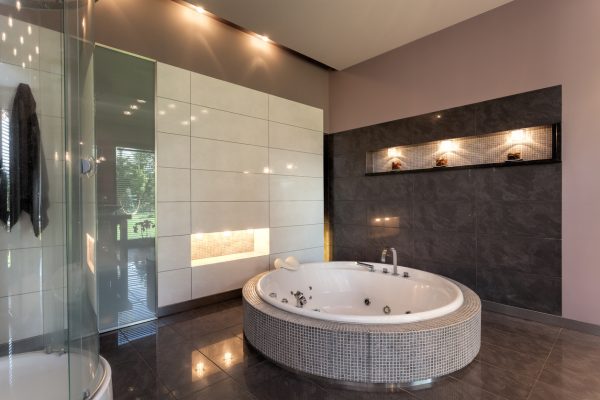 Round bath in a luxury tiled bathroom interior